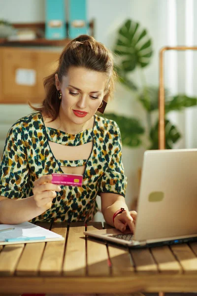 現代の中小企業の所有者クレジットカードとラップトップを持つ女性は オフィスで電子商取引のウェブサイト上でオンライン購入を行う — ストック写真