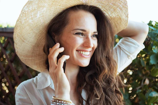 Sorrindo Mulher Moda Camisa Branca Com Chapéu Usando Smartphone Terraço — Fotografia de Stock