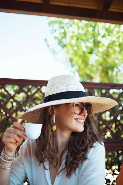 Glimlachende Trendy Huisvrouw Wit Shirt Met Kopje Koffie Hoed Bril — Stockfoto