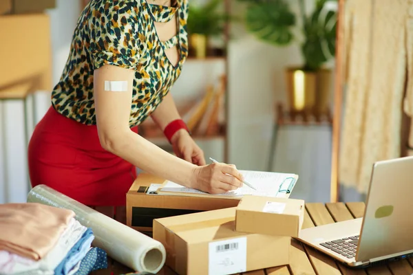 Closeup Small Business Owner Woman Plaster Coronavirus Vaccine Clipboard Parcel — Stock Photo, Image