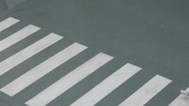 Beyaz kazaklı, sırt çantalı, yaya geçidinden geçen ve şehir dışındaki okula giden modern bir kızın üst görüntüsü..