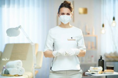 Koronavirüs salgını sırasında iş. Modern güzellik salonunda ffp2 maskeli orta yaşlı kadın işçinin portresi.