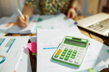 Vergi zamanı. Hesap makineli modern muhasebeci kadına yakın çekim Ofiste belgelerle çalışıyor..