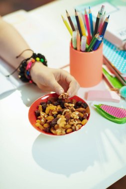 Güneşli bir günde evde sağlıklı atıştırmalıklar yiyen çocuğa yakın çekim.