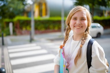 Şehrin yaya geçidinde beyaz kazaklı gülümseyen şık öğrencinin portresi..