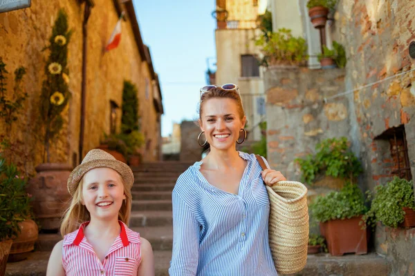 Travel in Italy. happy trendy mother and child travellers in Tuscany, Italy exploring attractions in Pienza.