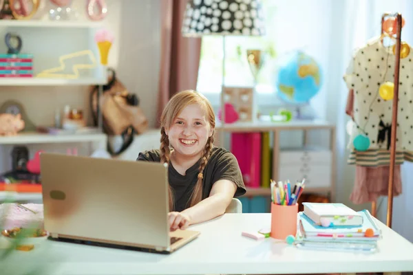 幸せな現代の女の子で灰色のシャツとノートパソコン学習オンラインで自宅で晴れた日に — ストック写真