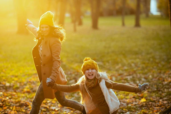 가을에 공원의 야외에서 노란색 모자를 어머니와 아이가 산책로를 즐기는 — 스톡 사진