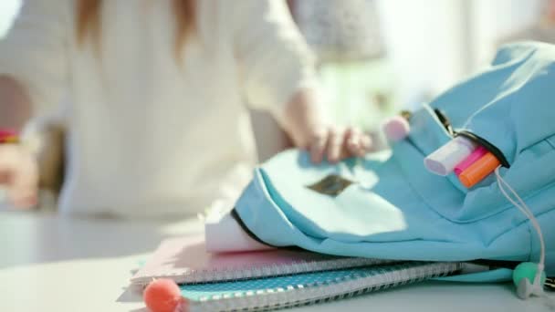 在阳光明媚的日子里 带着平板电脑 练习本和蓝色背包回家上学的女学生的衣服 — 图库视频影像
