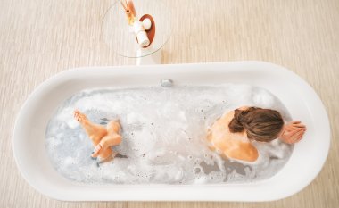Young woman laying in bathtub