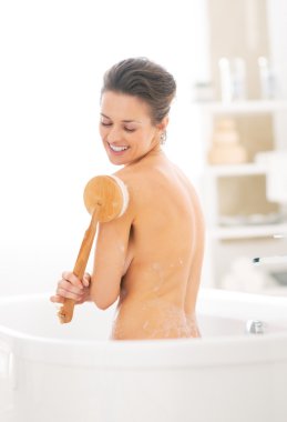 Genç kadın vücut fırçayla küvette