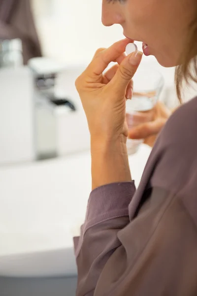 Primer plano de la mujer joven comiendo píldora — Foto de Stock