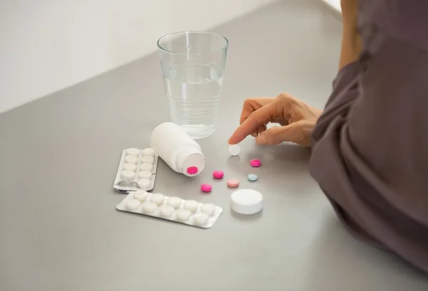 Primer plano de la joven mujer eligiendo pastillas —  Fotos de Stock