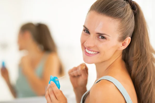 Portrait of happy young woman with dental floss — Stock Photo, Image