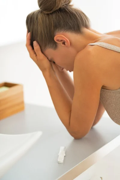 Primo piano sul test di gravidanza e frustrata giovane donna nel backgrou — Foto Stock