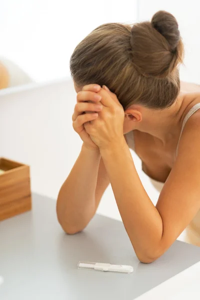 Portrait of frustrated young woman with pregnancy test — Stock Photo, Image