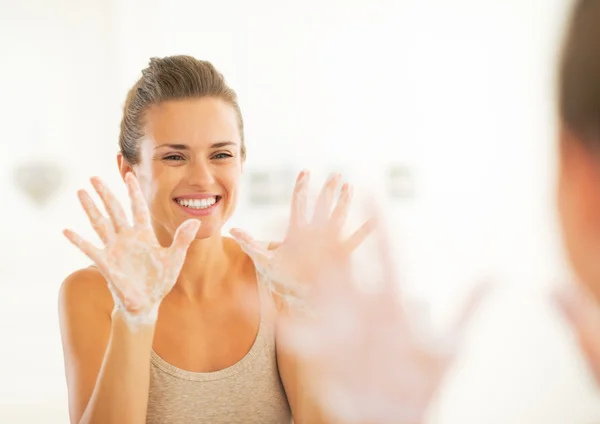 Felice giovane donna che mostra le mani saponate — Foto Stock