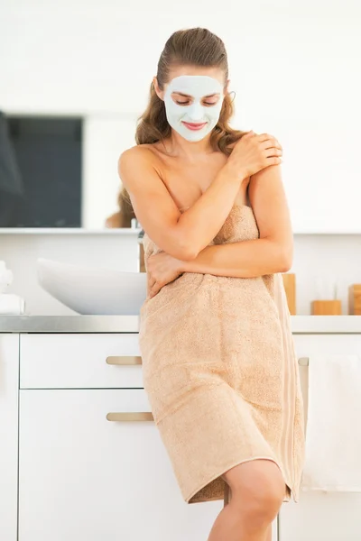 Ritratto di giovane donna con maschera cosmetica facciale in bagno — Foto Stock