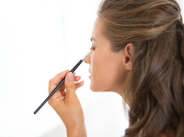 Jovem mulher aplicando maquiagem — Fotografia de Stock