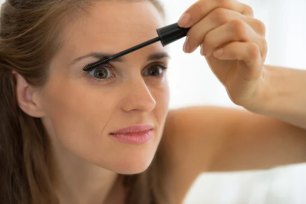 Portrait of young woman applying mascara — Stock Photo, Image