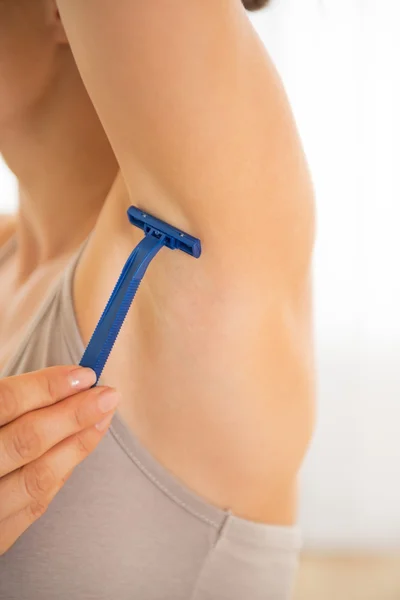 Closeup on young woman shaving armpit — Stock Photo, Image