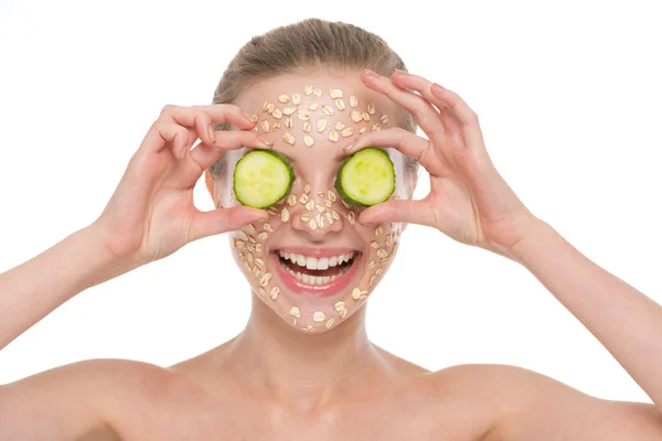 Mujer joven feliz con la fabricación de la máscara de avena con pepino —  Fotos de Stock