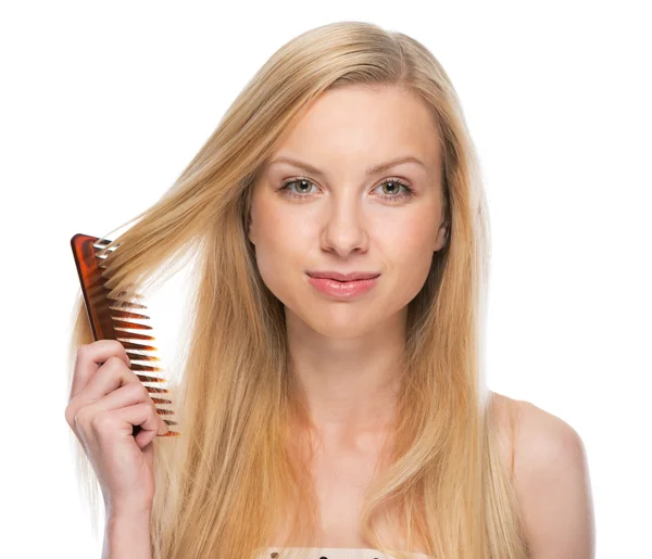 Mujer joven peinando el cabello — Foto de Stock