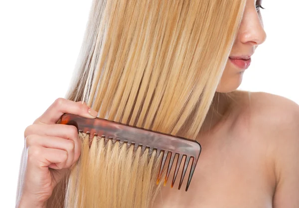 Primo piano sulla giovane donna pettinando i capelli — Foto Stock