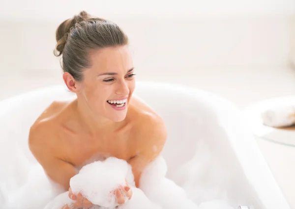 Feliz joven jugando con espuma en la bañera — Foto de Stock