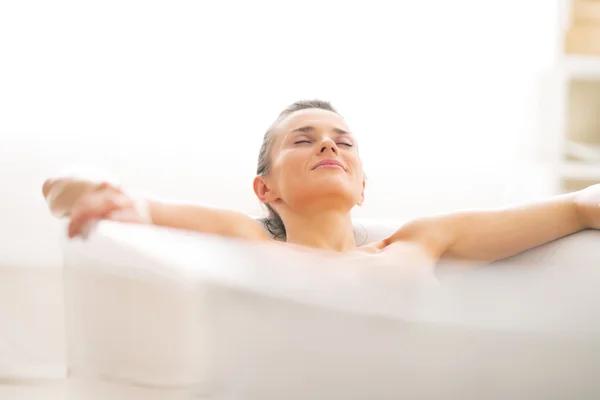 Relaxado jovem mulher deitado na banheira — Fotografia de Stock
