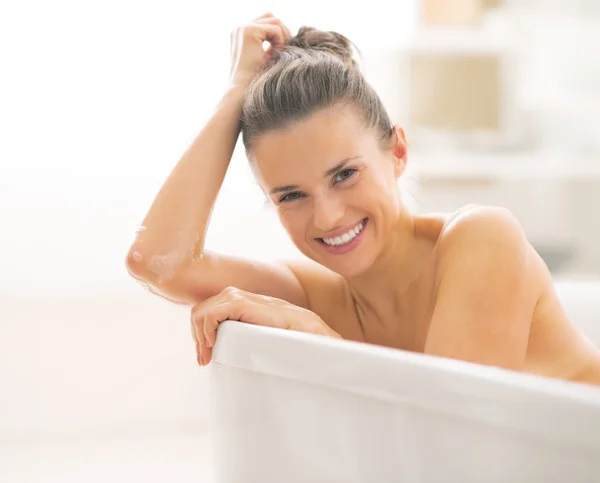 Portrait of smiling young woman in bathtub — Stock Photo, Image