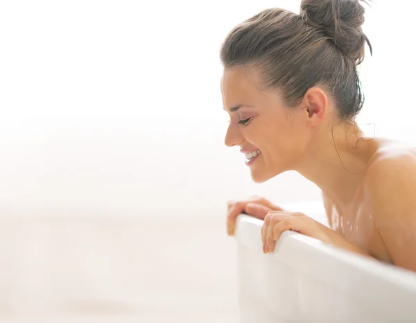 Young woman in bathtub looking on copy space — Stock Photo, Image