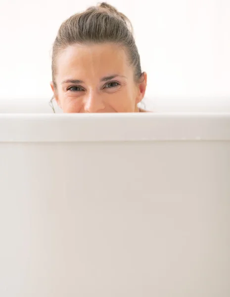 Young woman looking out from bathtub — Stock Photo, Image