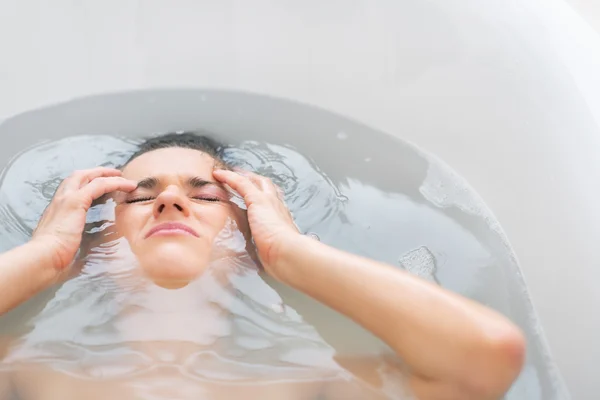 Gestresste junge Frau liegt in Badewanne — Stockfoto