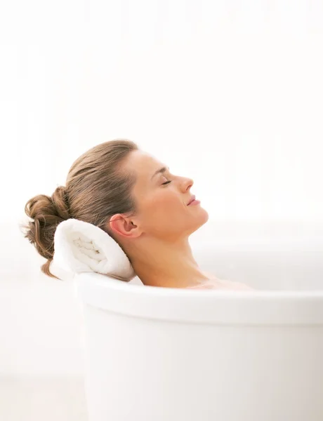 Relaxado jovem mulher deitado na banheira — Fotografia de Stock