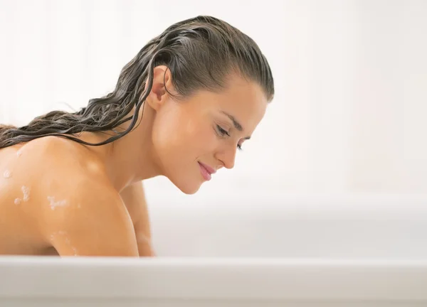 Junge Frau wäscht sich in Badewanne — Stockfoto