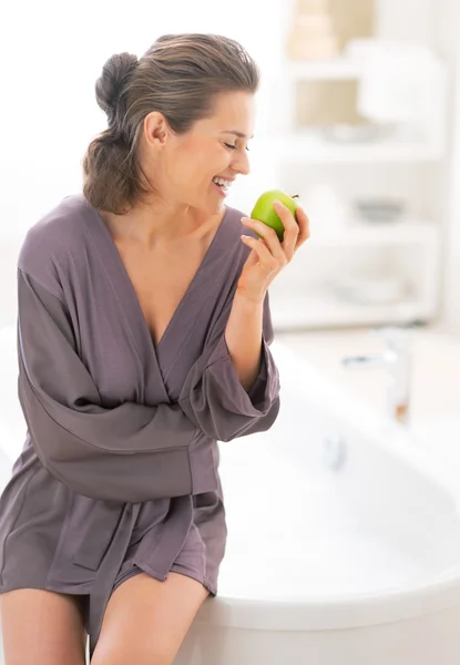 Giovane donna felice con mela vicino vasca da bagno — Foto Stock