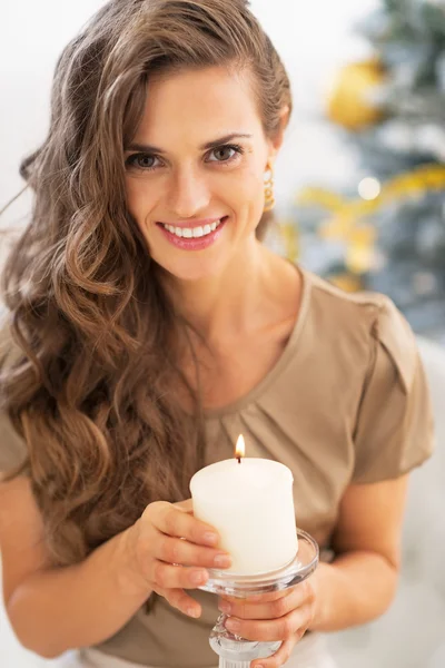 Портрет усміхненої молодої жінки зі свічкою біля ялинки — стокове фото