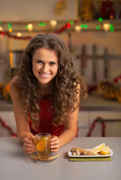 Jovem feliz bebendo chá na cozinha decorada de Natal — Fotografia de Stock