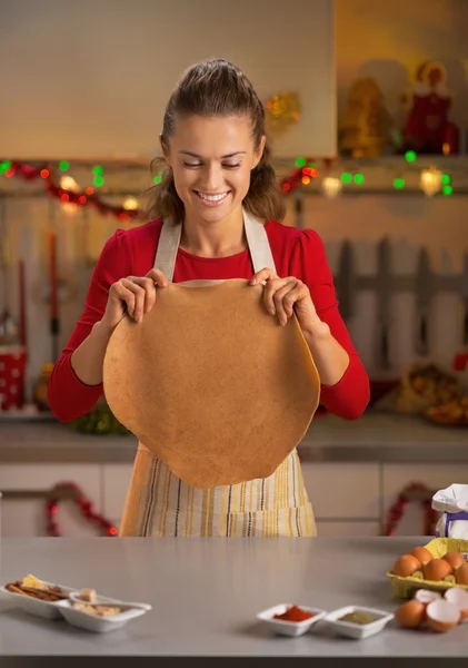 Glückliche junge Hausfrau macht Teig in weihnachtlich dekorierter Küche — Stockfoto