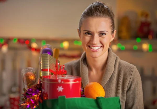 Portrét usměvavá mladá hospodyňka s vánoční Nákupní taška — Stock fotografie