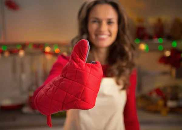 Close-up em feliz jovem dona de casa mostrando polegares na cozinha vermelha — Fotografia de Stock