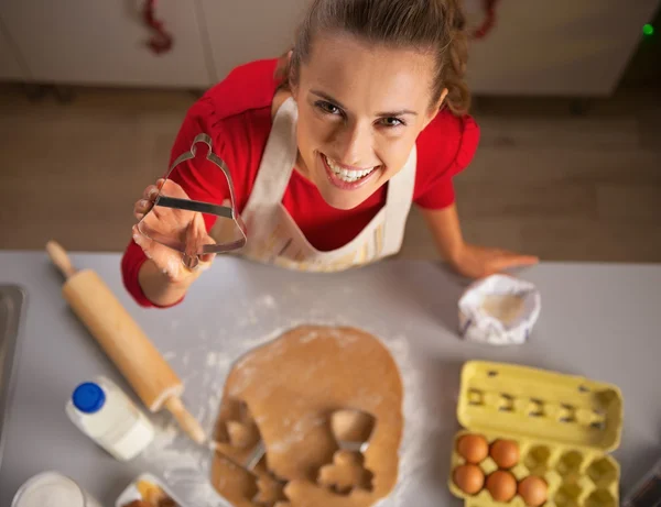 Happy young housewife showing christmas dough cutter — Stock Photo, Image