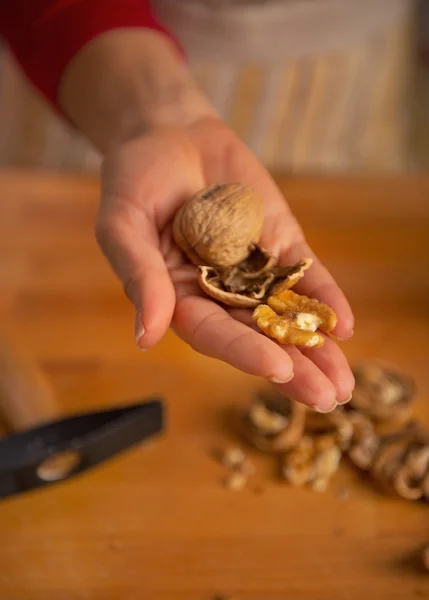 Joven ama de casa mostrando nueces — Foto de Stock