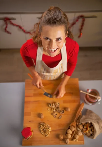 Porträt einer glücklichen jungen Hausfrau, die Walnüsse hackt — Stockfoto