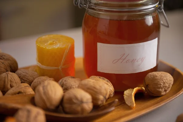 Closeup καρύδια και βάζο με μέλι στο τραπέζι — Φωτογραφία Αρχείου