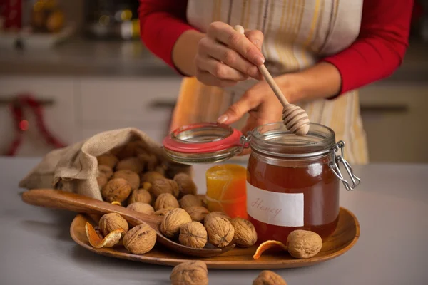 Gros plan sur la jeune femme au foyer mettre trempette de miel dans un pot de miel — Photo