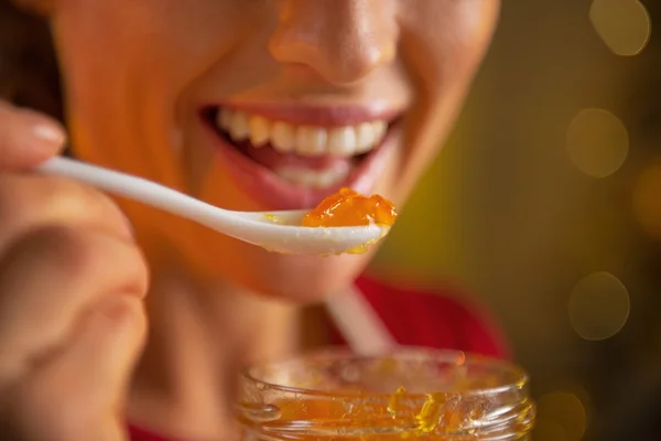 Primer plano de la mujer joven comiendo mermelada de naranja casera —  Fotos de Stock