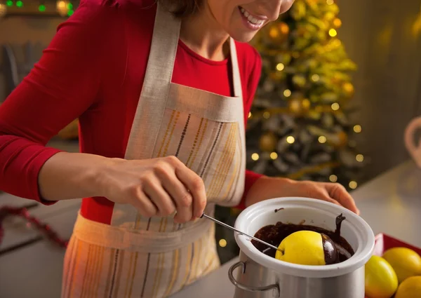 Close-up op jonge huisvrouw maken van apple in chocolade glazuur — Stockfoto