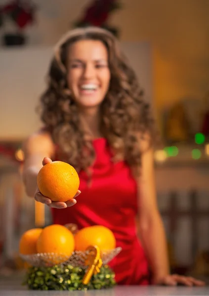 Close-up em feliz jovem dona de casa dando laranja — Fotografia de Stock